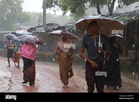 Rohingya Refugees Walk During A Monsoon Rain At Kutupalong Refugee Camp