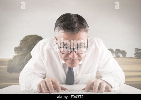 Composite Image Of Mature Businessman Typing On Keyboard Stock Photo