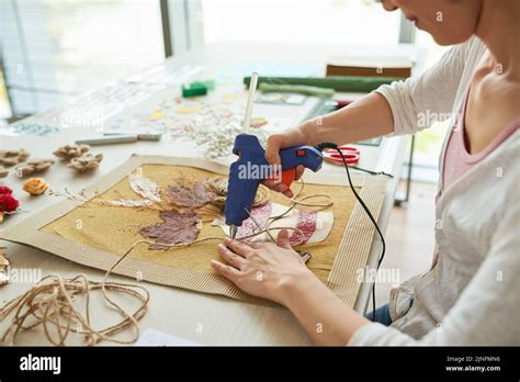 Profile View Of Unrecognizable Creative Woman Using Hot Glue Gun While Decorating Textile