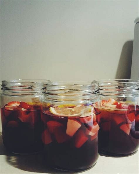 Four Jars Filled With Liquid Sitting On Top Of A Counter