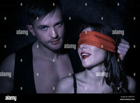 Sexy Portrait Of Male And Female Couple With Male Looking At Camera As Female Wears Red