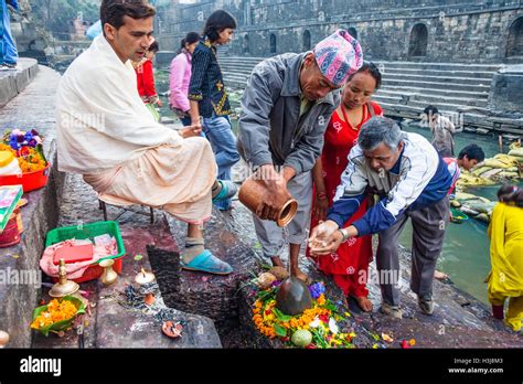 Nepali people performing puja by a shivalingam at Pashupatinath temple ...