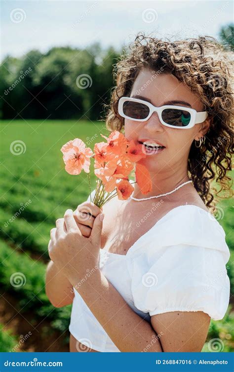 Young Curly Haired Woman In White Dress With A White Sunglasses Posing