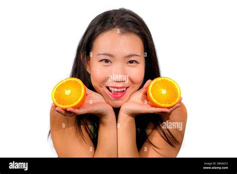 Young Beautiful And Happy Asian Korean Woman Holding Orange Fruit