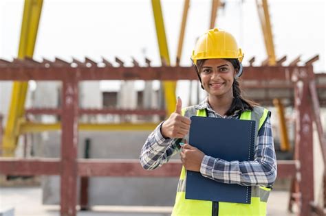 Mujer ingeniera asiática sosteniendo un documento que muestra el pulgar