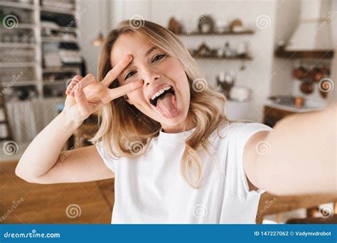 Image Closeup Of Attractive Blond Woman Showing Peace Sign While Taking