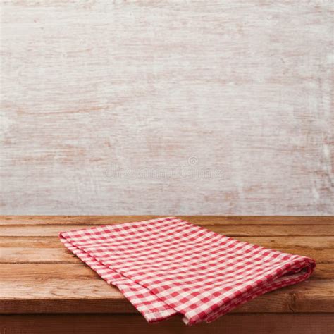 Empty Wooden Deck Table With Red Checked Tablecloth Over Rustic Wall