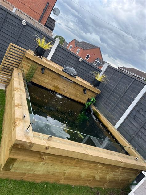 Fish Pond With Wooden Steps In Backyard