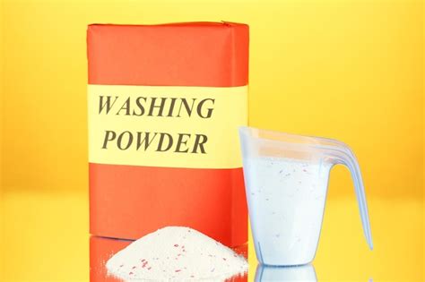 Premium Photo Box Of Washing Powder With Blue Measuring Cup On Orange