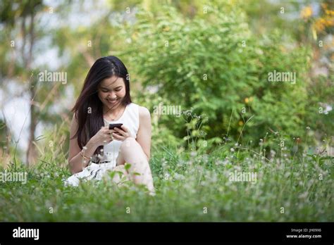 Jolie Femme Thaïlandaise à Laide De Mobile Au Parc Photo Stock Alamy