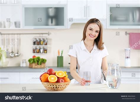 young woman drinking water glass kitchen stock photo edit