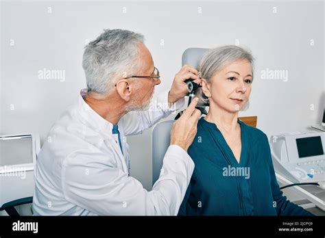 Otolaryngologist Doctor Checking Senior Woman S Ear Using Otoscope Or