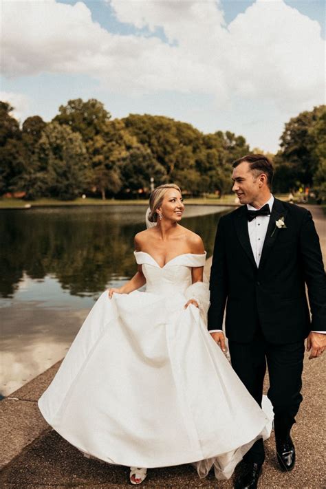 A Bride And Groom Are Walking By The Water