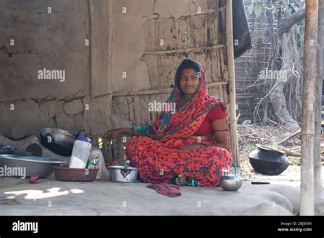 Rural Woman Cooking Food In The Kitchen Using Firewood Stove Stock