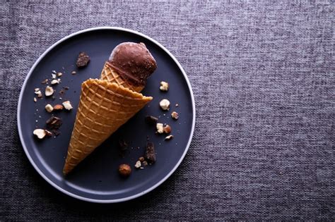 Sorvete De Chocolate Nozes Em Um Cone Num Prato Escuro Lugar