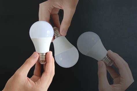 Premium Photo A Person Holding A Light Bulb That Is Being Held By Two