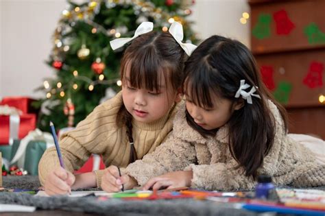 Dos jóvenes asiáticas felices disfrutan coloreando divirtiéndose y