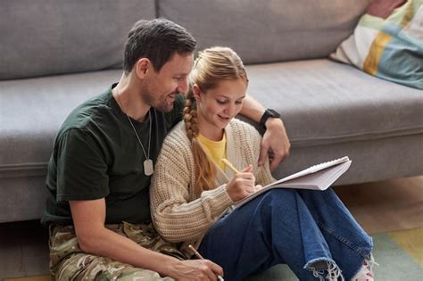 Père Militaire Attentionné Aidant Sa Fille à Faire Ses Devoirs Photo