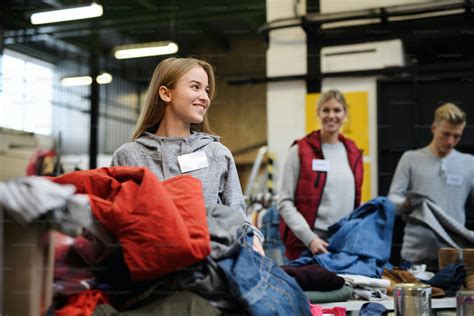 Portrait of volunteers sorting out donated clothes in community charity