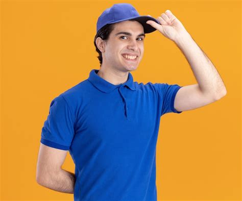 Repartidor Joven Sonriente En Uniforme Azul Y Gorra Mirando Al Frente