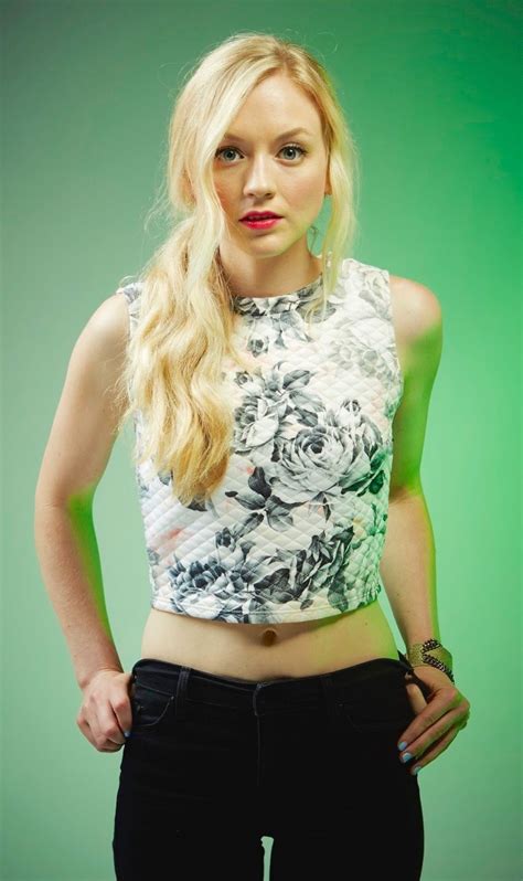 A Woman With Long Blonde Hair Wearing Black Pants And A Crop Top Is