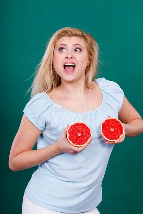 La Mujer Sostiene Los Agrios Del Pomelo En El Pecho Imagen De Archivo