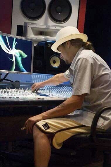 A Man Sitting In Front Of A Mixing Desk