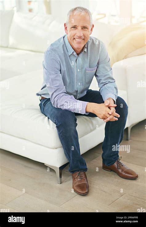 Happy At Home Portrait Of A Smiling Mature Man Sitting On A Sofa In