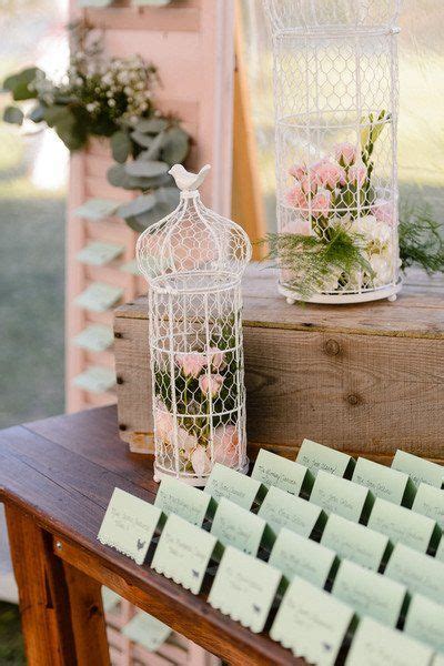 A Wooden Table Topped With Lots Of Cards Next To A Birdcage Filled With