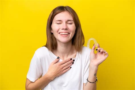 Premium Photo | Young english woman holding invisible braces smiling a lot