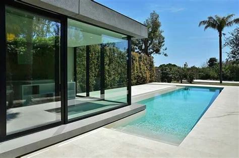 An Empty Swimming Pool In The Middle Of A Large Backyard With Glass