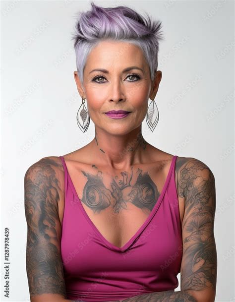 Studio Portrait Of A Forty Years Old Short Haired Tattoed Model With Nude Shoulders Wearing A