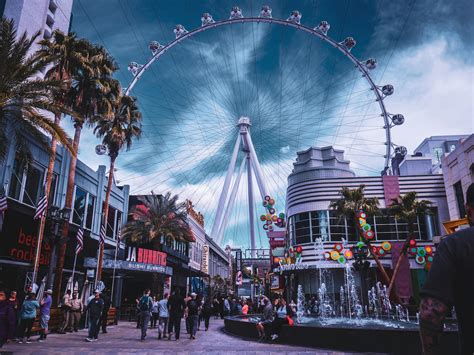 People Walking On Amusement Park Near Buildings · Free Stock Photo