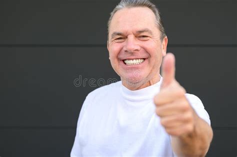 Smiling Mature Man Showing His New Teeth And Giving A Thumbs Up Gesture