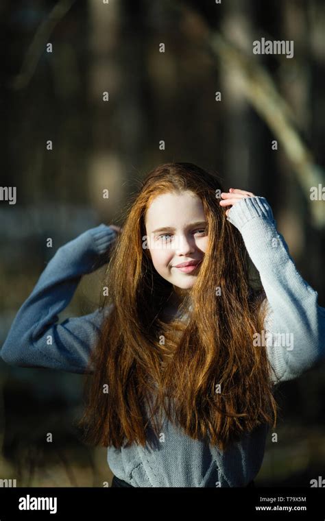 Portrait Of Cute Twelve Year Old Girl With Fiery Red Hair Posing In The