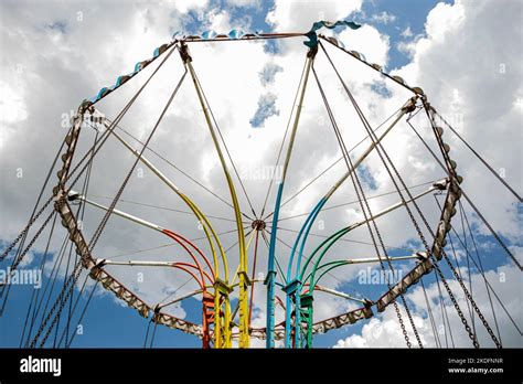 A Low Angle Shot Of A Colorful Turning Carousel Ride Under A Bright Sky