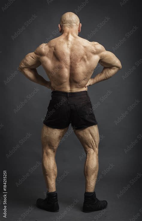 Athlete In Back Lat Spread Pose Bodybuilder Showing Muscles On Studio