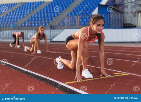 Women Sprinters At Starting Position Ready For Race On Racetrack Stock