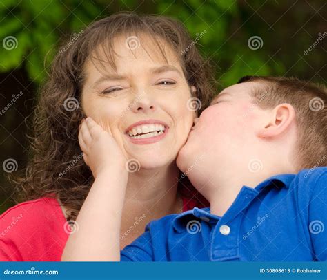 Mère heureuse souriant au baiser du fils