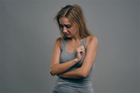 Fille blonde bouleversée avec des cheveux ébouriffés et des ecchymoses sur son visage en maillot