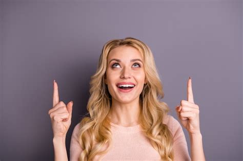 Premium Photo Charming Blonde Woman In Pink Sweater Posing Against The Purple Wall