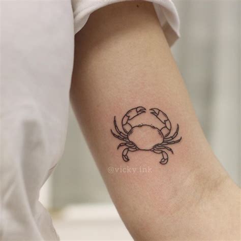 A Small Crab Tattoo On The Left Inner Arm And Wrist Done In Black Ink