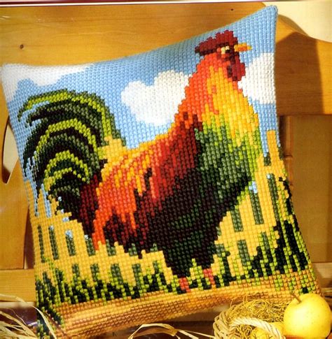 A Cross Stitch Pillow With An Image Of A Rooster On It And Some Eggs