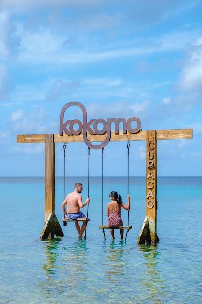 Premium Photo | Couple at a swing in the ocean of curacao caribbean island kokomo beach curacao