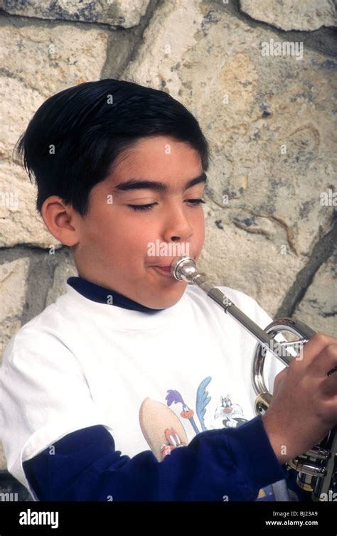 Hispanic niño de nueve años toca la trompeta instrumento musical golpe