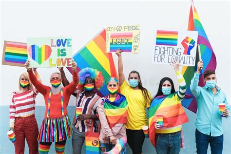 Multiracial Gay People With Rainbow Mask At Lgbt Pride Parade Outdoors Focus On Faces Stock
