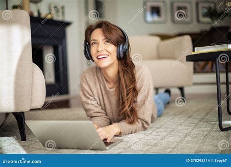 Happy Woman Wearing Headphone And Using Laptop At Home Stock Photo