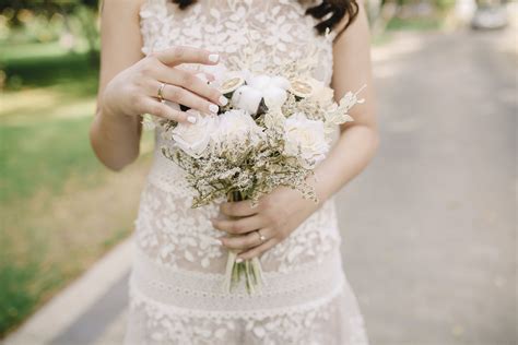 Photo of Woman's Hand Holding Out White Flowers In Front of White ...