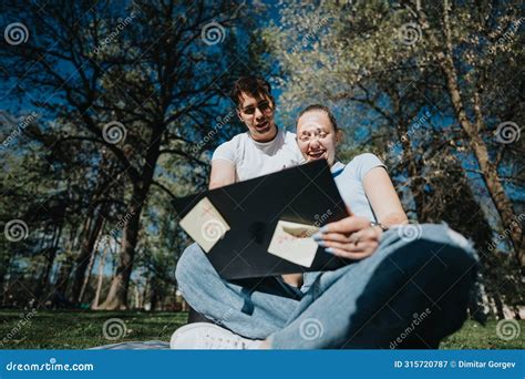 High School Students Collaborating On Homework In A Sunny Park Stock