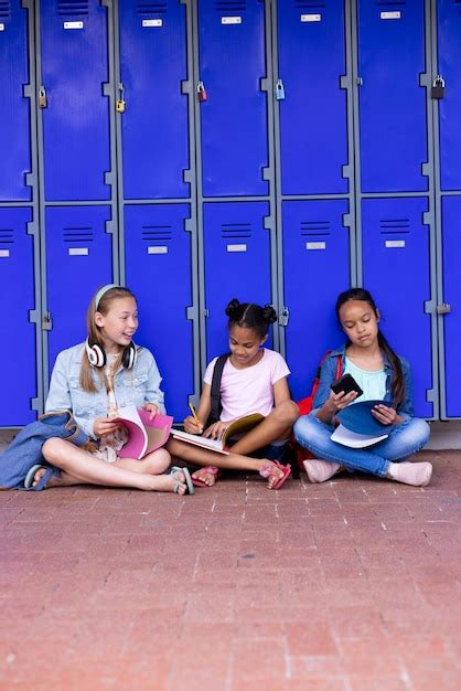 Estudiantes Felices Y Diversos Sentados Junto A Los Armarios En El